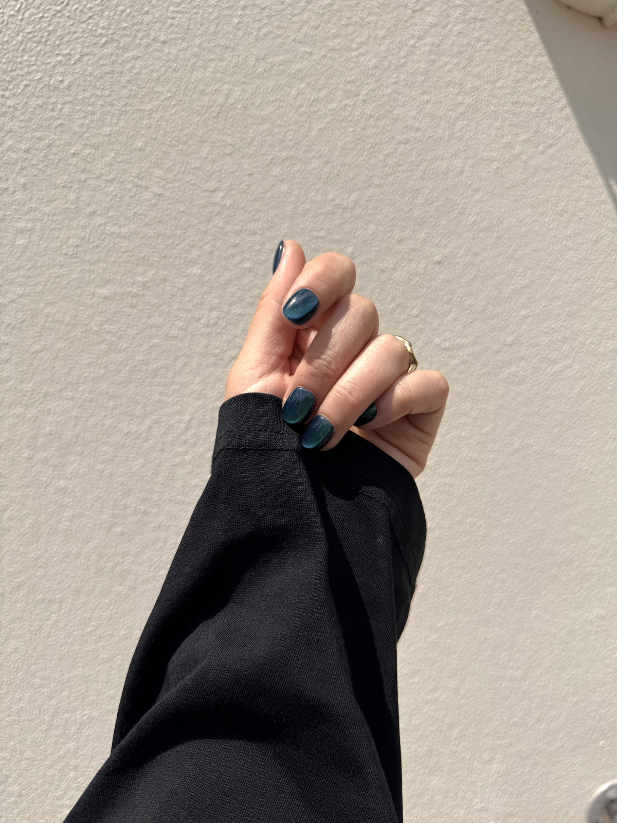 Emerald Frost short squoval cat eye press on nails worn outdoors
