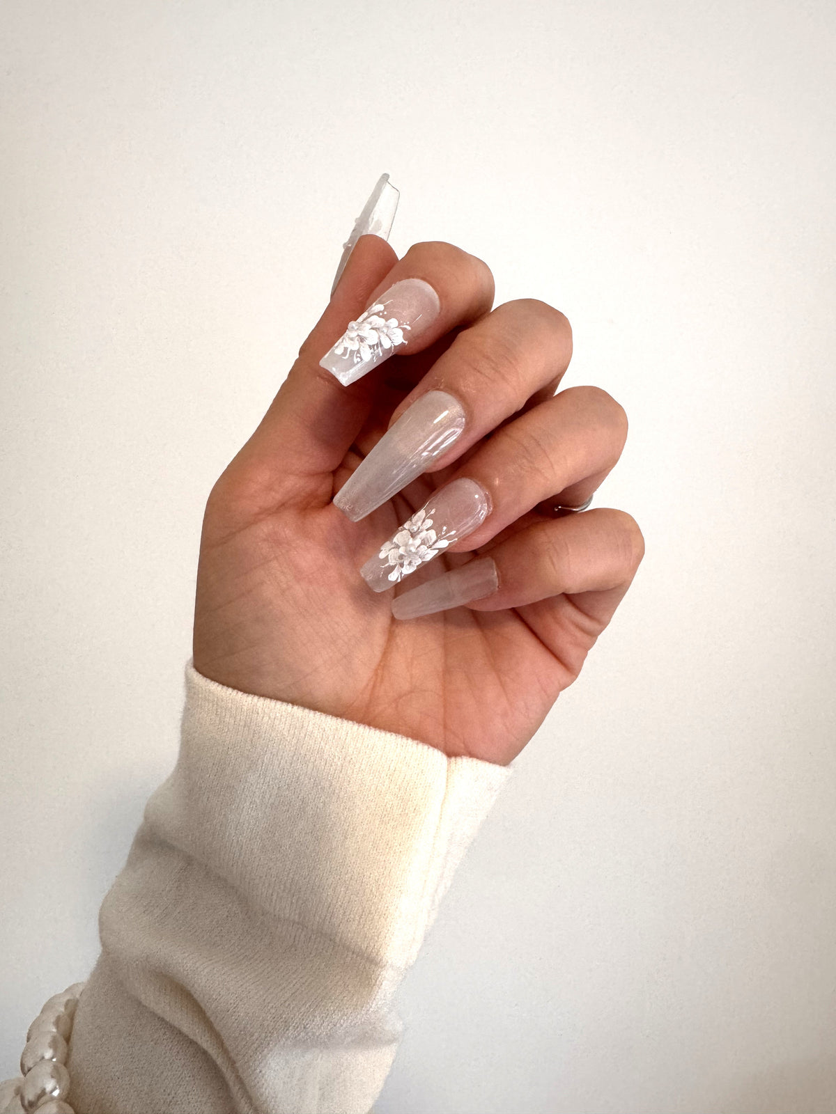 Pearl Bloom hand-painted white floral Long Coffin press-on nails worn on hand
