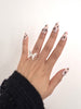Noir Rose hand-painted black floral Medium Almond press-on nails worn on hand
