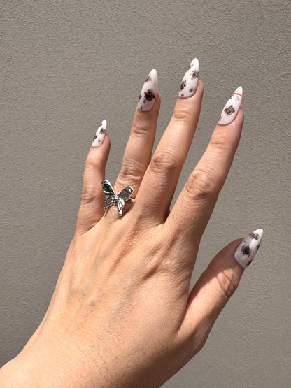 Noir Rose Medium Almond floral press-on nails in natural sunlight